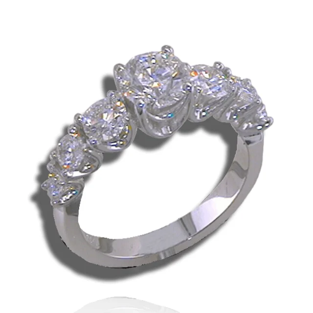 Graduated diamond ring with a prominent centre stone and smaller stones tapering along a plain polished band.