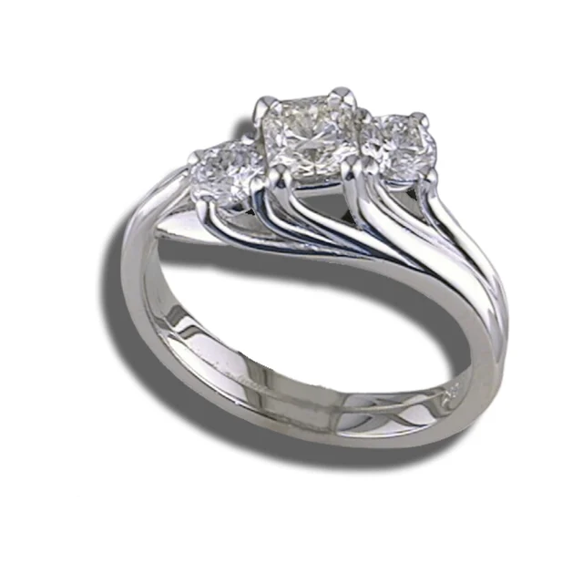 Three-stone diamond ring with a softly squared centre and sweeping polished supports beneath the stones.