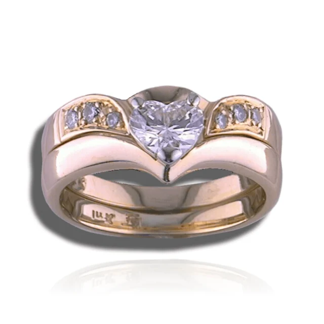 Heart-shaped centre diamond set into a broad gold design with a pointed lower contour and diamond-set shoulders.