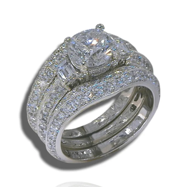 Diamond ring with a large centre stone, a baguette accent and broad curved rows of smaller diamonds.
