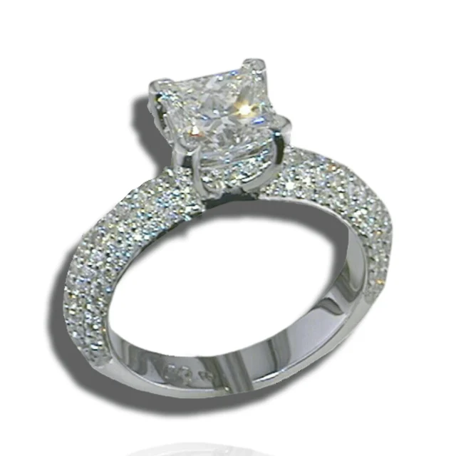 Raised square centre stone with diamonds beneath the setting and multiple pavé rows across the band.