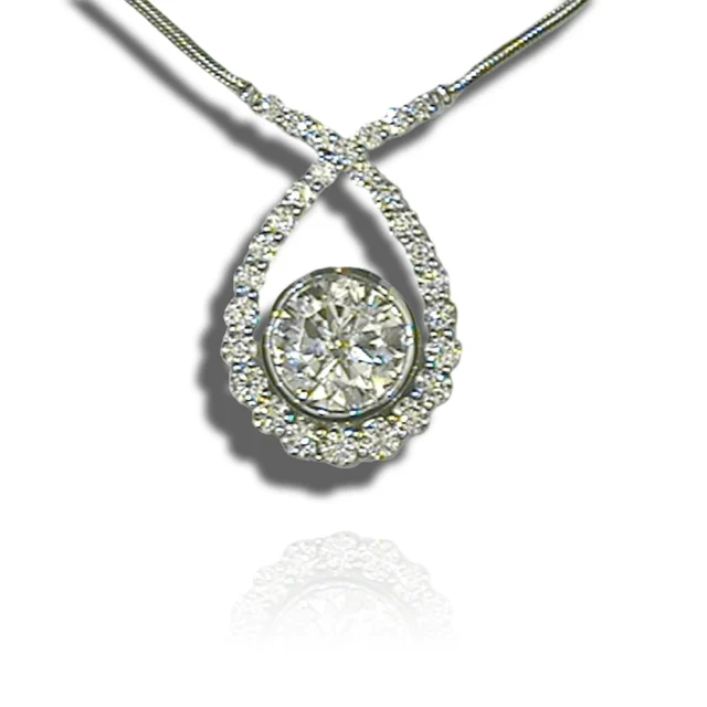Round bezel-set centre stone inside an open teardrop pendant edged with diamonds and crossed at the top.